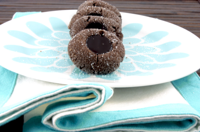 Chocolate Thumbprints A photo of chocolate thumbprints on a blue flowered white plate on a blue and white napkin placed on a wooden placemat.