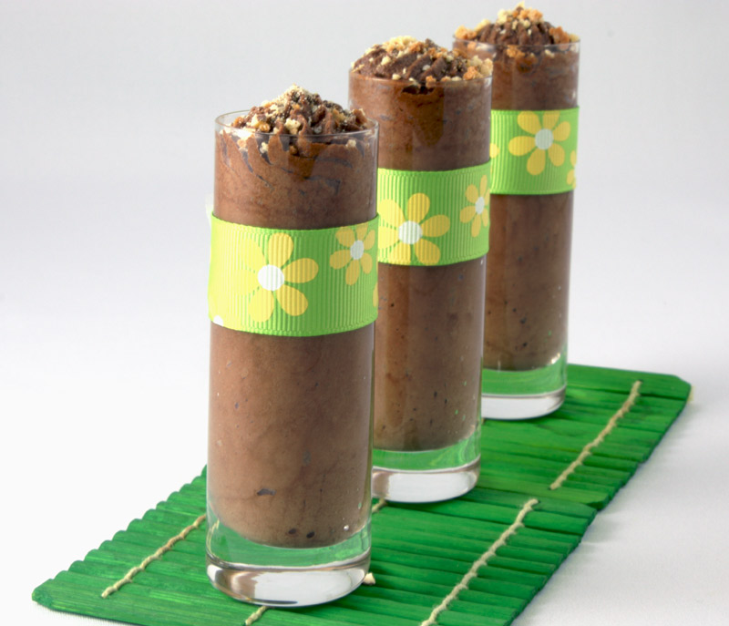 Gordon Ramsay Four-Minute Chocolate Mousse A photo of chocolate mousse in 3 individual shot glasses with yellow and green ribbon attached on green wooden coasters.