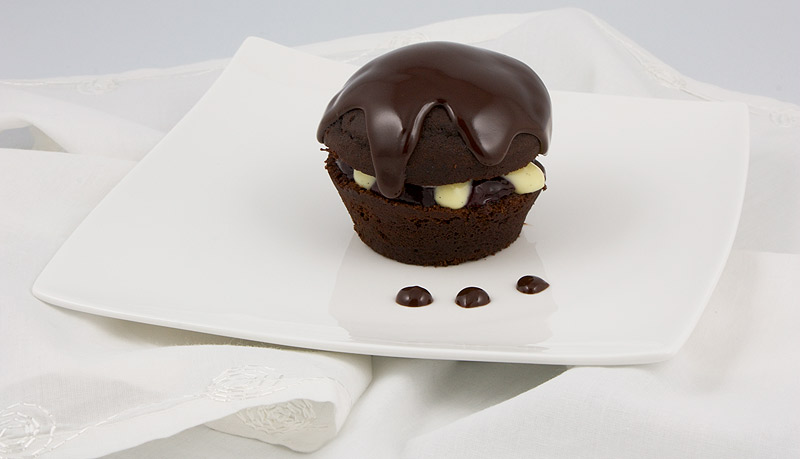 Martha Stewart's Black Forest Cupcakes A photo of a black forest cupcake on a white plate with chocolate drops, placed on a white napkin.