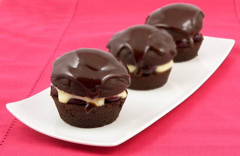 Martha Stewart's Black Forest Cupcakes A photo of 3 black forest cupcakes on a white plate, placed on a pink placemat.