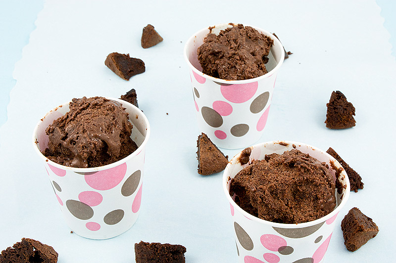 Italian semifreddo dessert recipes, Donna Hay's double chocolate brownie semifreddo recipe, Donna Hay's double chocolate brownie semifreddo A close up photo of 3 double chocolate brownie semifreddo desserts in pink and brown polka dotted paper cups, sitting on a piece of parchment with small brownies bites scattered around the cups.