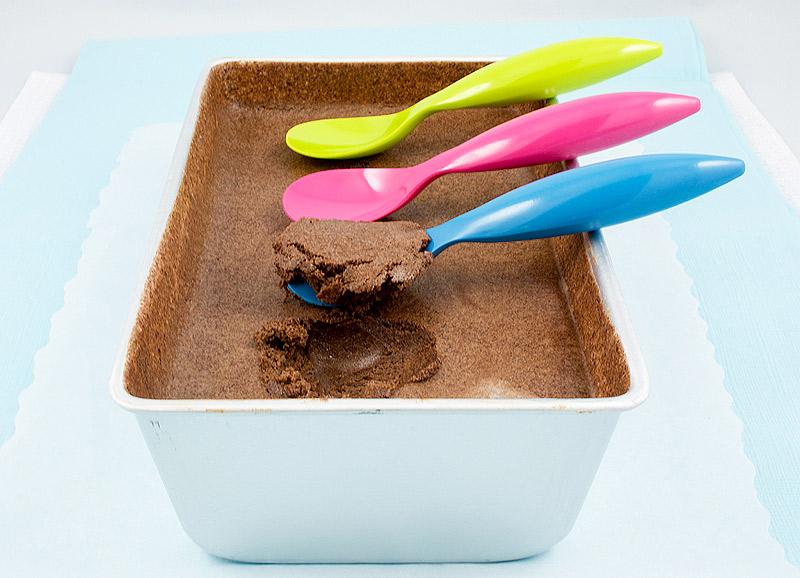 double chocolate brownie semifreddo, Donna Hay's double chocolate brownie semifreddo recipe, Donna Hay's semifreddo recipes A photo of Donna Hay's double chocolate semifreddo in a tin baking dish with three plastic spoons, one blue, one pink and one yellow, arranged in a row, one with a scoop of semifreddo.