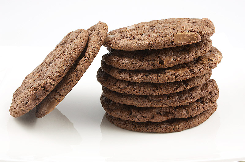 Martha Stewart cookie recipes, Martha Stewart's double chocolate chunk cookies, double chocolate chunk cookie recipe, easy double chocolate cookie recipe A photo of a stack of double-chocolate chunk cookies with an additionally 2 cookies leading against the stack of cookies on a white napkin.