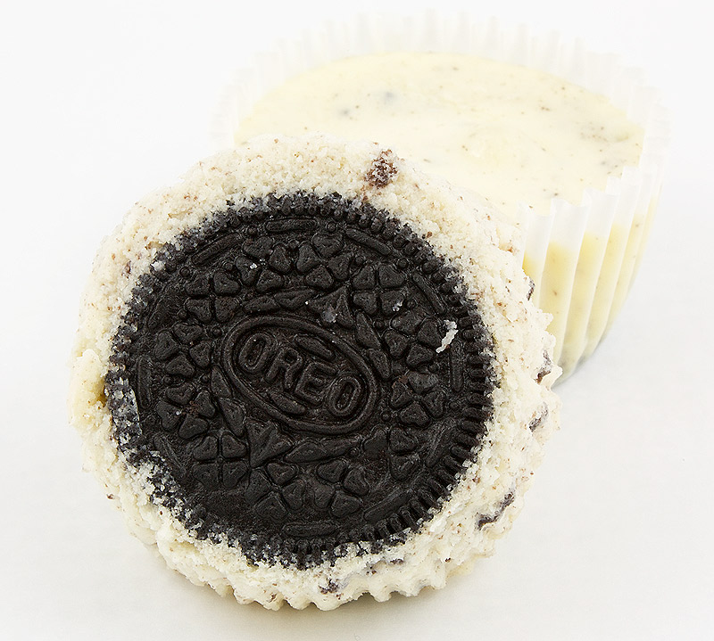 Oreo cookies and cream cheesecake cupcakes, Martha Stewart's cupcake recipes, cookies and cream cheesecakes recipe A photo of 2 Oreo cookies and cream cheesecake cupcakes, 1 unwrapped Oreo cookie side up, and one wrapped.