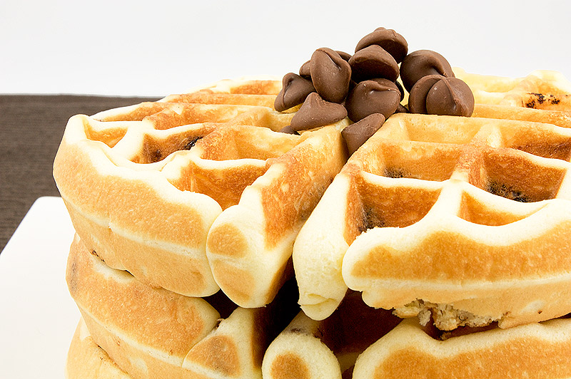 recipe for Belgian Waffles with chocolate chips, homemade chocolate chip waffles, homemade chocolate chip belgian waffles A close up photo of a stack of chocolate chip belgian waffles garnished with chocolate chips.
