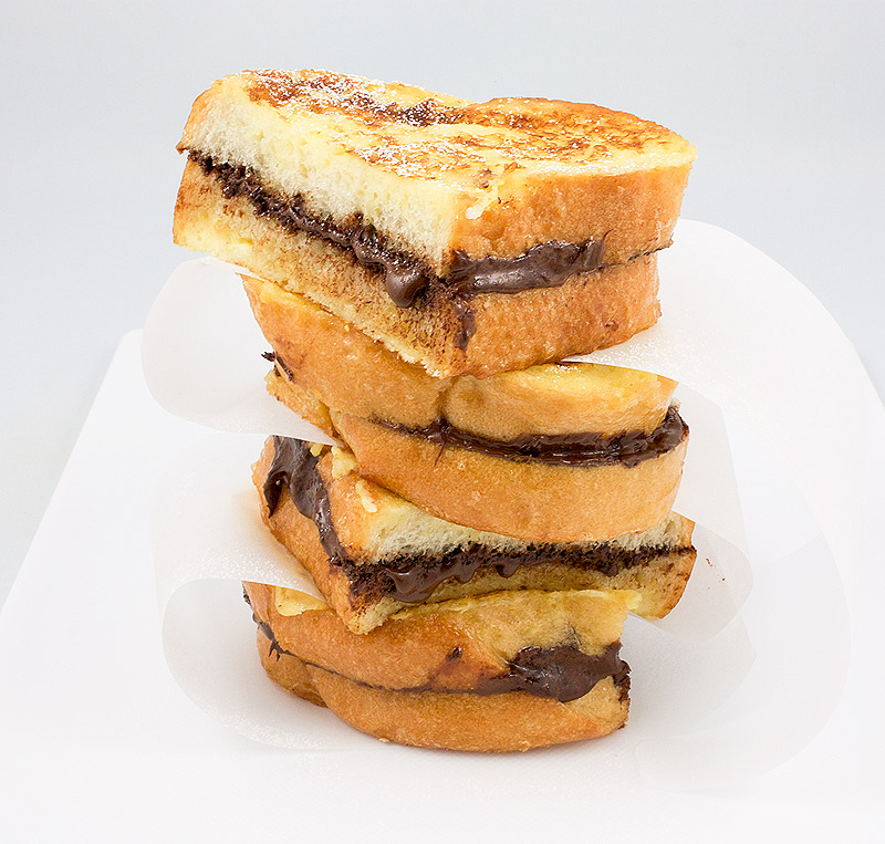 extra special breakfast recipes, extra special brunch recipe, quick and easy extra special breakfast ideas A photo of a stack of slices of chocolate french toast with parchment paper in between the slices.
