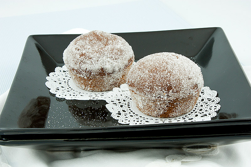 sugar donut muffin recipe, easy chocolate muffin recipe A photo of 2 Sugared Chocolate-Spiced Muffins on white doilies placed on a small, black square plate.