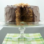 recipe for salted candied peanuts, how to make salted candied peanuts, how to make easy ganache frosting A photo of David Lebovitz's Banana Cake with Mocha Frosting and Salted Candied Peanuts with a slice removed and displayed on a glass cake stand.