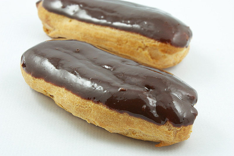 Chocolate Éclairs with Vanilla Bean Crème Pâtissière and Chocolate Ganache Glaze French pastries A close up photo of 2 Chocolate Éclairs with Vanilla Bean Crème Pâtissière and Chocolate Ganache Glaze French pastries.