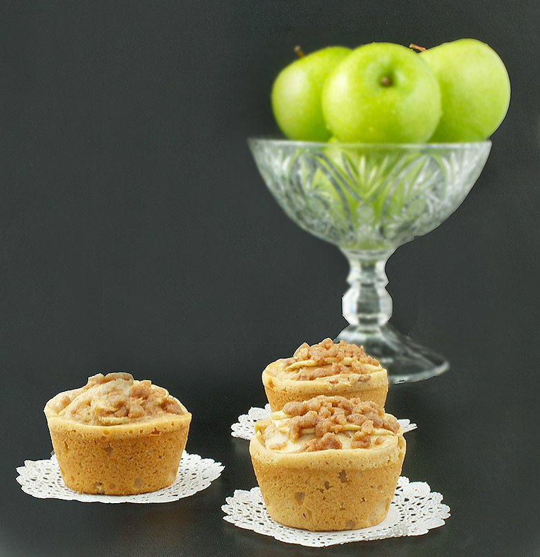apple crumb cake, crumb cake recipe, apple crumb cake recipe A photo of 3 Warm Apple Cinnamon Crumb Cakes with Calvados on white doilies with a bowl of green apples in the background.