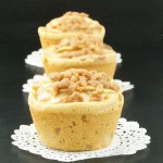 Warm Apple Cinnamon Crumb Cakes with Calvados A photo of three Warm Apple Cinnamon Crumb Cakes with Calvados on white doilies placed in a row.