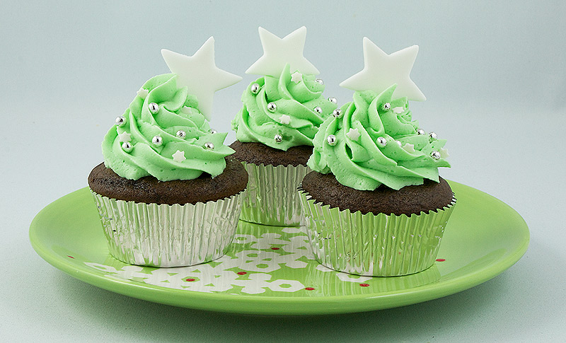 Dark Chocolate Cupcakes with Peppermint Marshmallow Cream Filling A photo of 3 Dark Chocolate Cupcakes with Peppermint Marshmallow Cream Filling and topped with green-tinted Swiss Meringue Buttercream on a green Christmas plate.