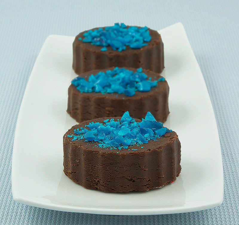 Chocolate Marshmallow Fudge A photo of 3 pieces of Chocolate Marshmallow Fudge decorated with crushed blue candy canes.