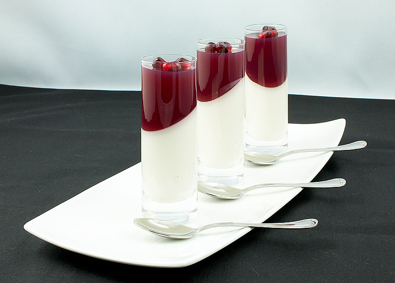 pomegranate juice recipe, easy Italian desserts, Italian panna cotta A photo of 3 Vanilla-Coconut Panna Cotta with Pomegranate Jelly desserts placed in a row on a white rectangular dish.