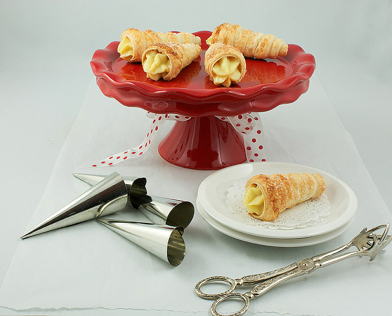 Cream Horns A photo of Cream Horns displayed on a red cake stand.