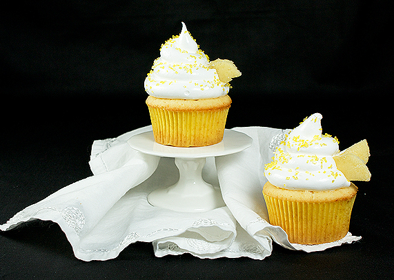 yellow cupcakes, meringue frosting, yellow cupcake recipe A photo of 2 Beehive Cupcakes (Yellow Cupcakes with Meringue Icing) sprinkled with yellow sanding sugar displayed on a mini cake stand.