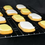 Spiced Honey Fingers A photo of Spiced Honey Fingers decorated with white and yellow Cookie Icing.p on a wire cooling rack.