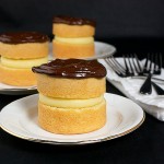 Boston Cream Pies A photo of three Mini Boston Cream Pie desserts served on white dessert plates.