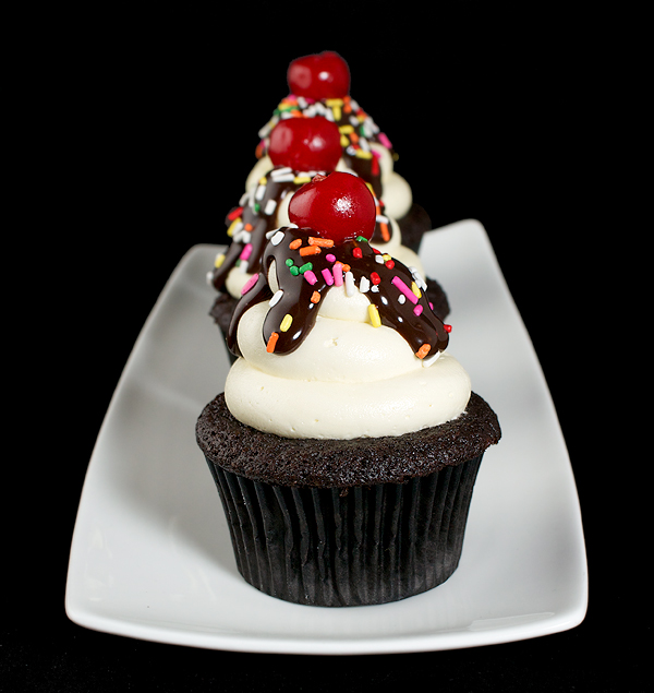 hot fudge sundaes, moist chocolate cupcakes, chocolate cupcakes recipe A photo of three Hot Fudge Sundae Cupcakes displayed in a row on a white rectangular shaped dish.