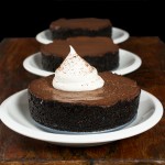 Chocolate Cream Pies A photo of three mini Chocolate Cream Pies served on small white dessert dishes placed in a row, one behind the other with the first one garnished with a dollop of Sweetened Whipped Cream and grated chocolate.