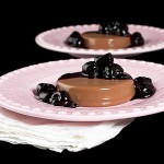Milk Chocolate Panna Cotta with Port Cherry Sauce A photo of two Italian Desserts, Milk Chocolate Panna Cotta with Port Cherry Sauce served on pink dessert dishes.