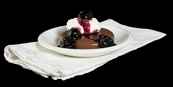 Italian Dessert A photo of an Italian Dessert, Panna Cotta served with a Port Cherry Sauce and a quenelle of Sweetened Whipped Cream.