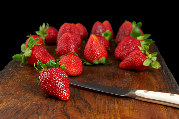 Fresh Strawberries A photo of fresh strawberries displayed on a dark wooden board.