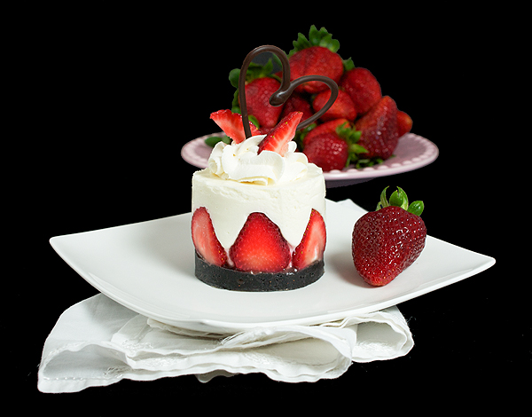 Italian Dessert A photo of an Italian Dessert, Yogurt Mousse Cake with Strawberries and garnished with strawberries, sweetened whipped cream and a chocolate heart.