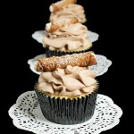 Cannoli Cupcakes A photo of 3 Cannoli Cupcakes placed in a row, one behind the other, decorated with tiny cannoli.