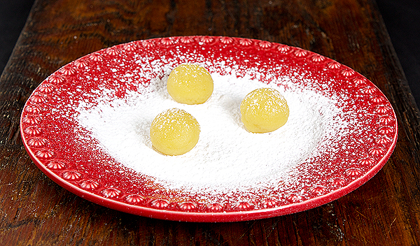 Italian Sweet - Amaretti Cookies A photo of Italian Sweet - Amaretti cookie dough rolled in balls on a bed of confectioners' sugar.