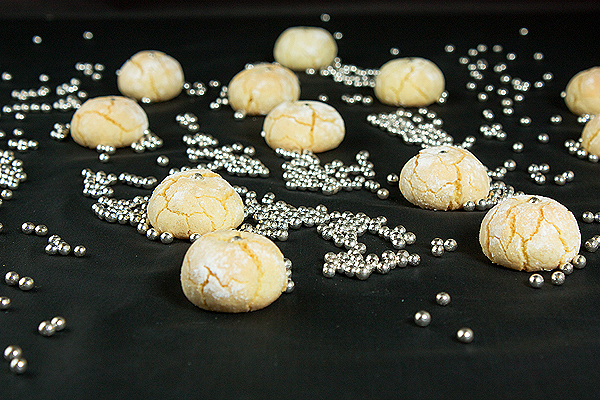 Italian Cookies A photo of Italian Cookies, Amaretti, displayed on black fabric with randomly scattered silver dragees.