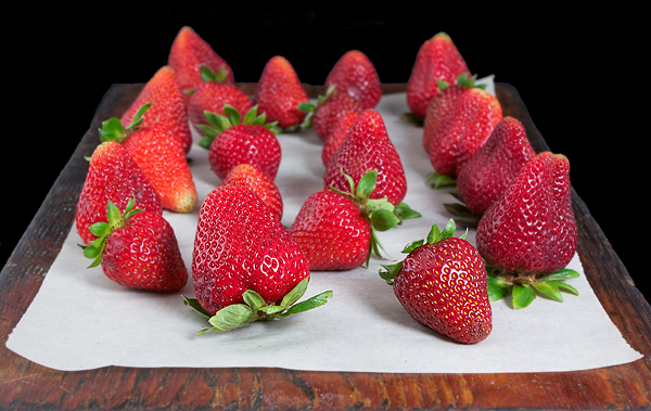 crostata, recipes tart, recipe strawberry tart A photo of fresh strawberries displayed on a wooden board to be used in a Italian Dessert, Crostata di Fragole.