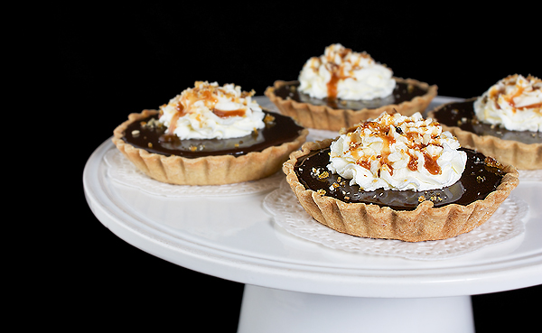 Chocolate Tarts A photo of Chocolate Tarts with Caramel drizzle on top and a sprinkle of hazelnut praline.