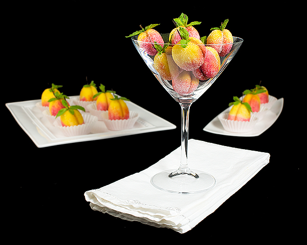 Italian Pastry A photo of Italian Pastries, Pesche Dolci - Italian Peach Cookies decorated to resemble fresh peaches, displayed in white dishes and a martini glass.
