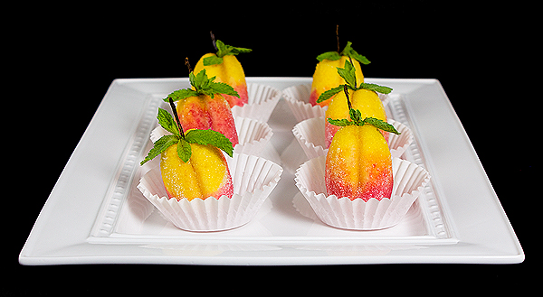 Pesche A photo of 6 Pesche {Italian Peach Cookies} filled with Crema Pasticcera displayed on a white dish.