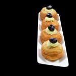zeppole di san giuseppe 2 A photo of 4 Zeppole di San Giuseppe, St. Joseph's Day Fritters on a white rectangular dish set off to the side.