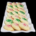 short bread A photo of various short bread christmas cookies decorated with red and white candy cane sprinkles and green sprinkles.