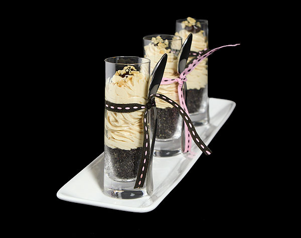 Grace's Sweet Life Peanut Butter Parfait A photo of 4 mini Peanut Butter Parfaits served in shot glasses with pink and brown ribbon tied around glasses holding the dessert spoon.