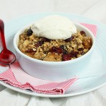 Grace's Sweet Life Apple Crisp A photo taken looking down on an Apple Crisp dessert topped with a dollop of sweetened whipped cream.