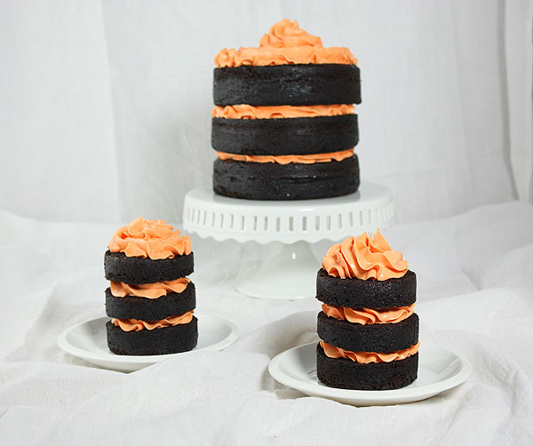 Pumpkin Chocolate Cake from Grace's Sweet Life A photo of a three-layer Pumpkin Chocolate Cake displayed on a white cake stand and two mini three-layer Pumpkin Chocolate Cakes displayed on white dessert plates.