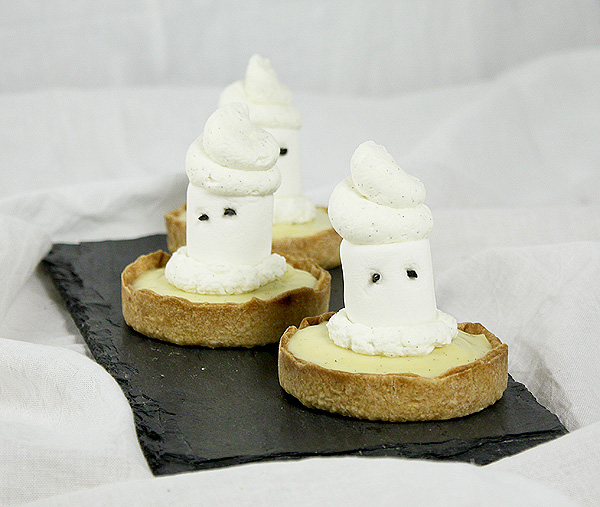 Ghost Tarts from Grace's Sweet Life A photo of three Ghost Tarts displayed in a row on a rectangle shaped slate board.