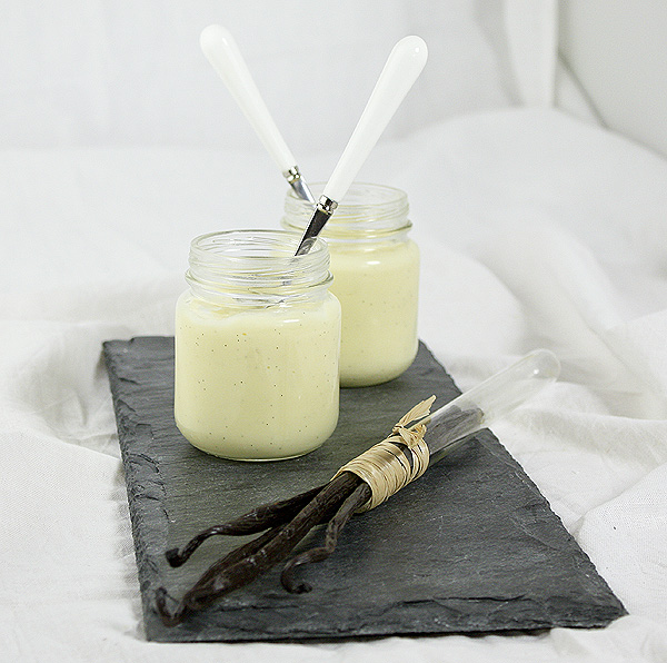 Grace's Sweet Life Vanilla Bean Pudding Vanilla Bean Pudding displayed with Vanilla Beans in glass tube on a slate board.