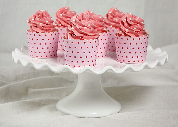 A photo of Gourmet Strawberry Cupcakes on white cake stand.