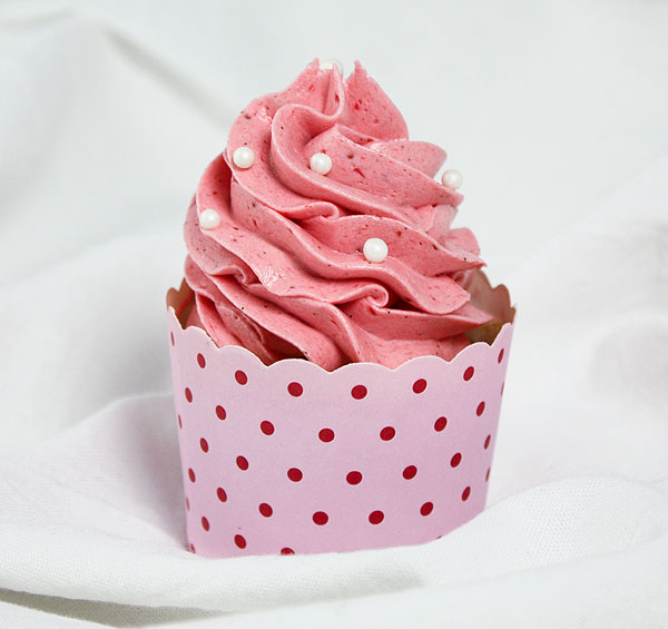 Close up photo of a Strawberry Cupcake with Pink Strawberry Frosting decorated with white sugar pearls in red dotted pink cupcake cup.