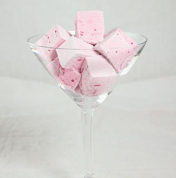 Close up photo of Boozy Strawberry Marshmallows displayed in a martini glass.