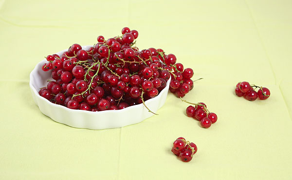 Photo taken looking down on bowl of red currants.