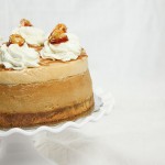 Cropped and close up photo of Dulce de Leche Cheesecake with layer of Caramel Mousse on white cake stand.
