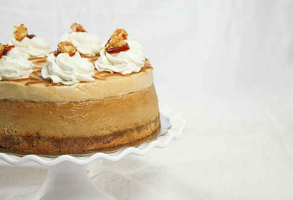 Cropped and close up photo of Dulce de Leche Cheesecake with layer of Caramel Mousse on white cake stand.