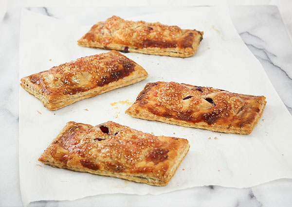 Image taken looking down on freshly baked Berry Hand Pies lightly coated with warm blackberry glaze.