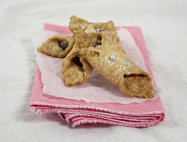 Nutella cookies stacked on white and pink striped cloth napkin lined with parchment paper.